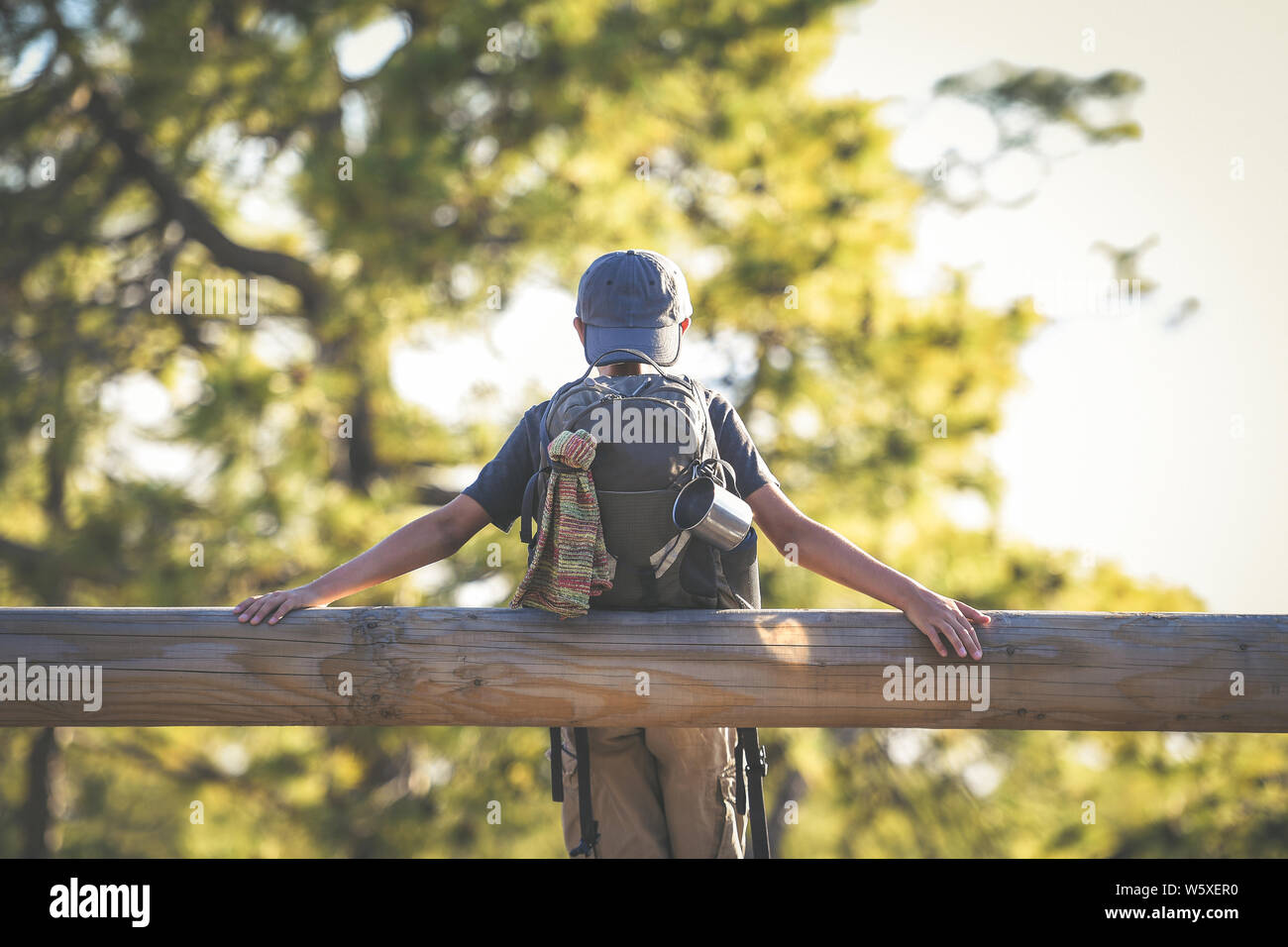 Young boy alone waiting for a ride on the side of the street. Teen with ...