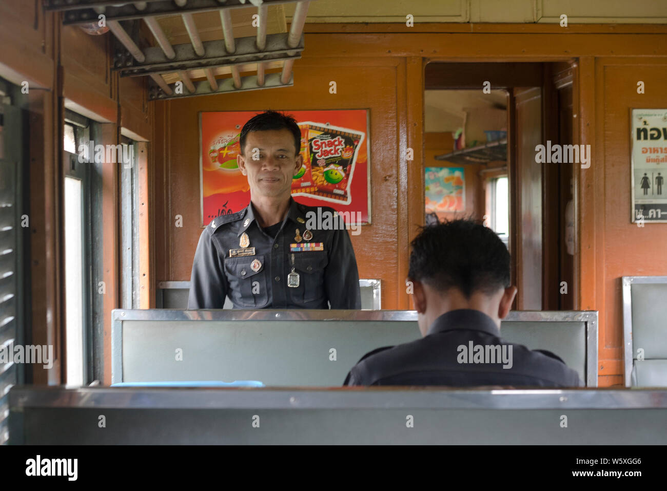 2 workers on the train from Bangkok to Kanchanaburi, Thailand. Stock Photo