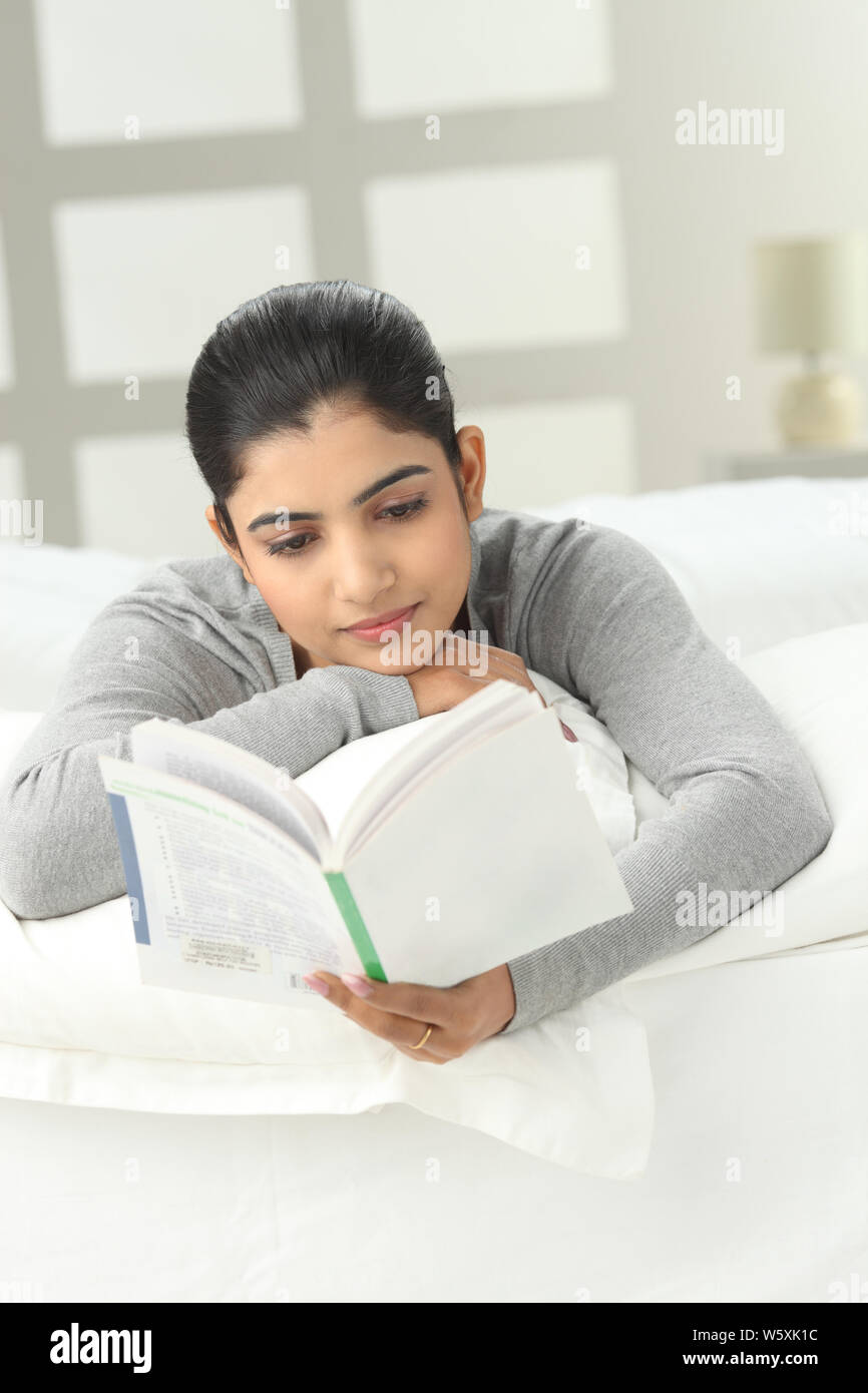 Indian girl reading book bed hi-res stock photography and images - Alamy