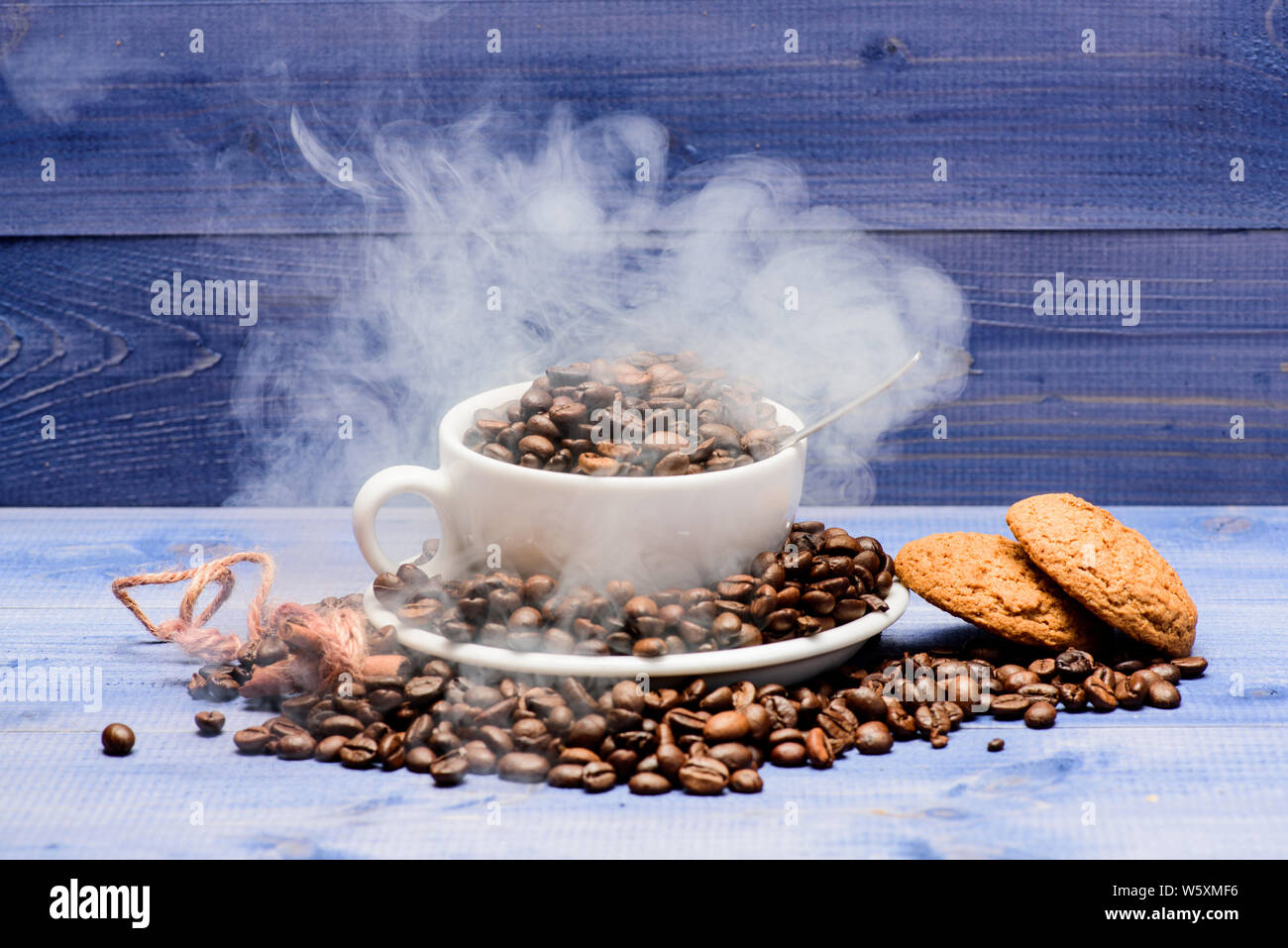 Cafe Drinks Menu Fresh Roasted Coffee Beans Coffee For Inspiration And Energy Charge Degree Of Roasting Grain Cup Full Coffee Brown Roasted Beans White Clouds Of Smoke Blue Wooden Background Stock Photo
