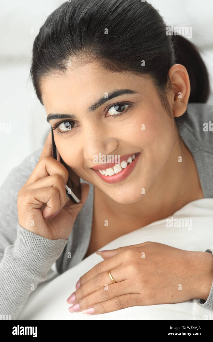 Indian young woman talking on a mobile phone and smiling Stock Photo ...