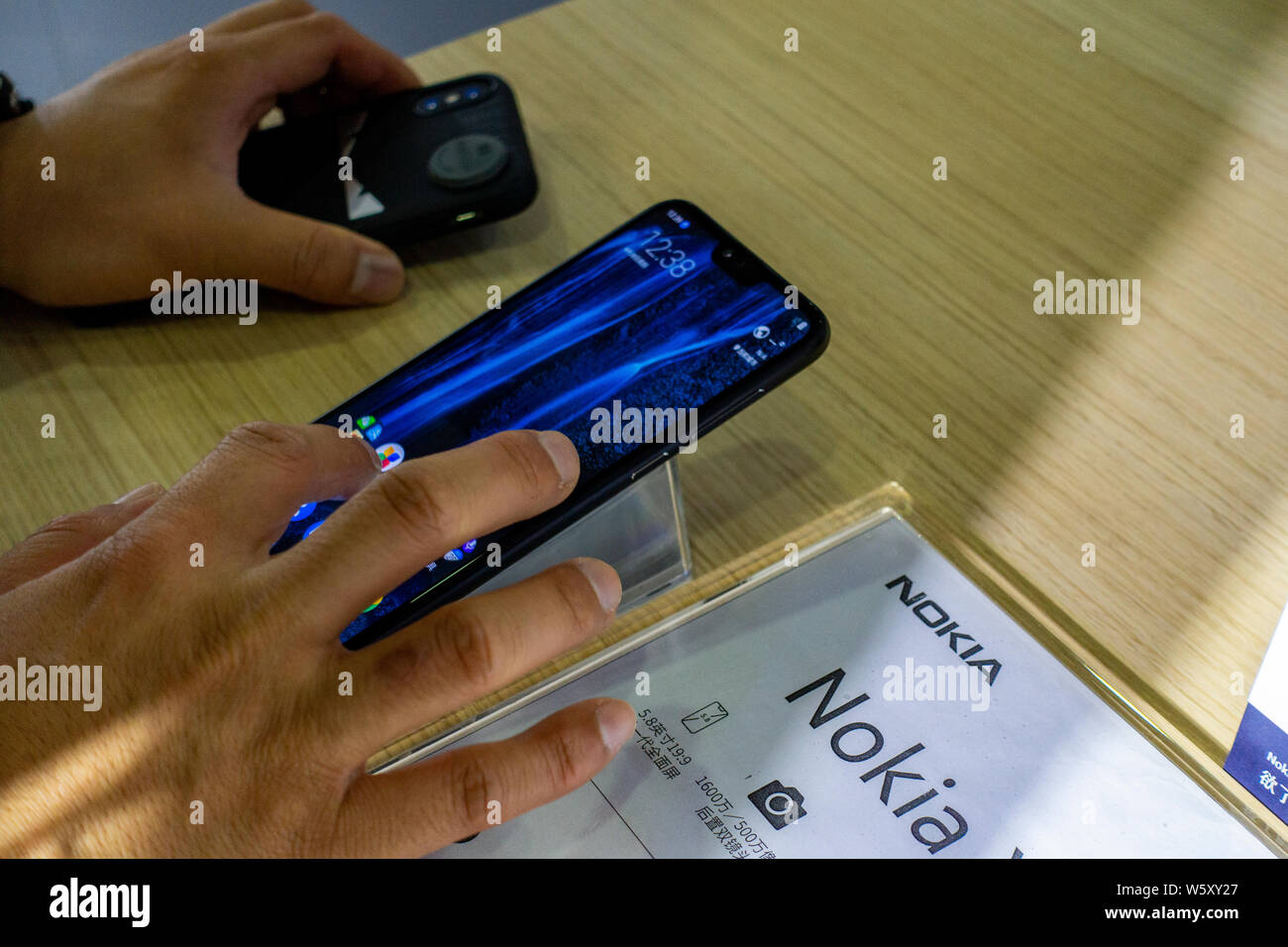 --FILE--A visitor tries out a Nokia X6 during the 2018 Mobile World Congress (MWC) in Shanghai, China, 29 June 2018.   Finnish mobile telecom network Stock Photo