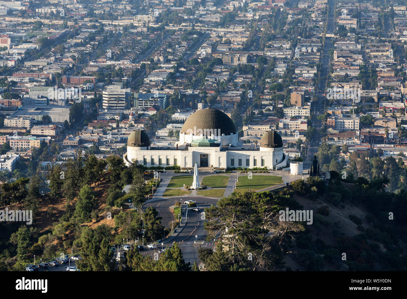 Los Angeles, California, USA - July 28, 2019:  Early morning view of Griffith Park Observatory with urban city streets and buildings in background. Stock Photo