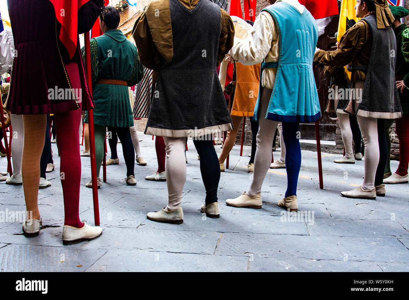 Men in medieval tights and costumes get ready to participate in the annual Palio parade in Siena, Italy Stock Photo