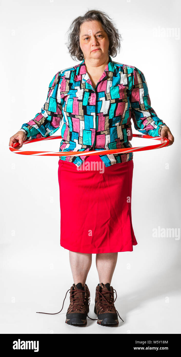 Senior woman poses wearing silly, funny, mismatched outfits and ready for a fashion show runway highlighting the weird, zany, quirky and eccentric. Stock Photo