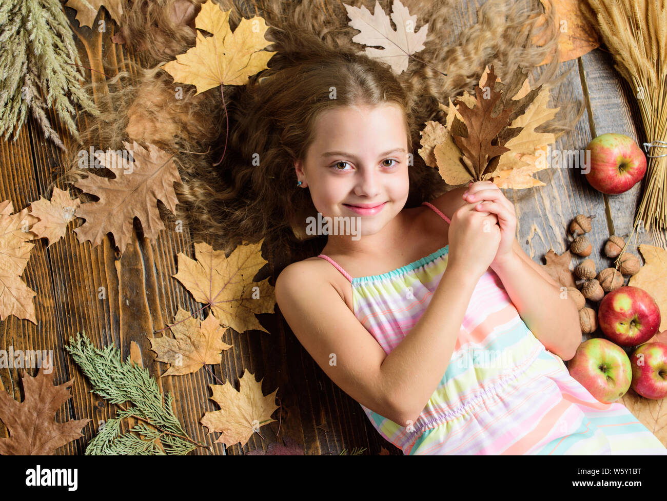 Her hair at its best. Little girl with wavy hairstyle on fall background.  Small beauty model with fall look. Hair salon for kids. Pretty girl with  long hairstyle. Cute girl with natural