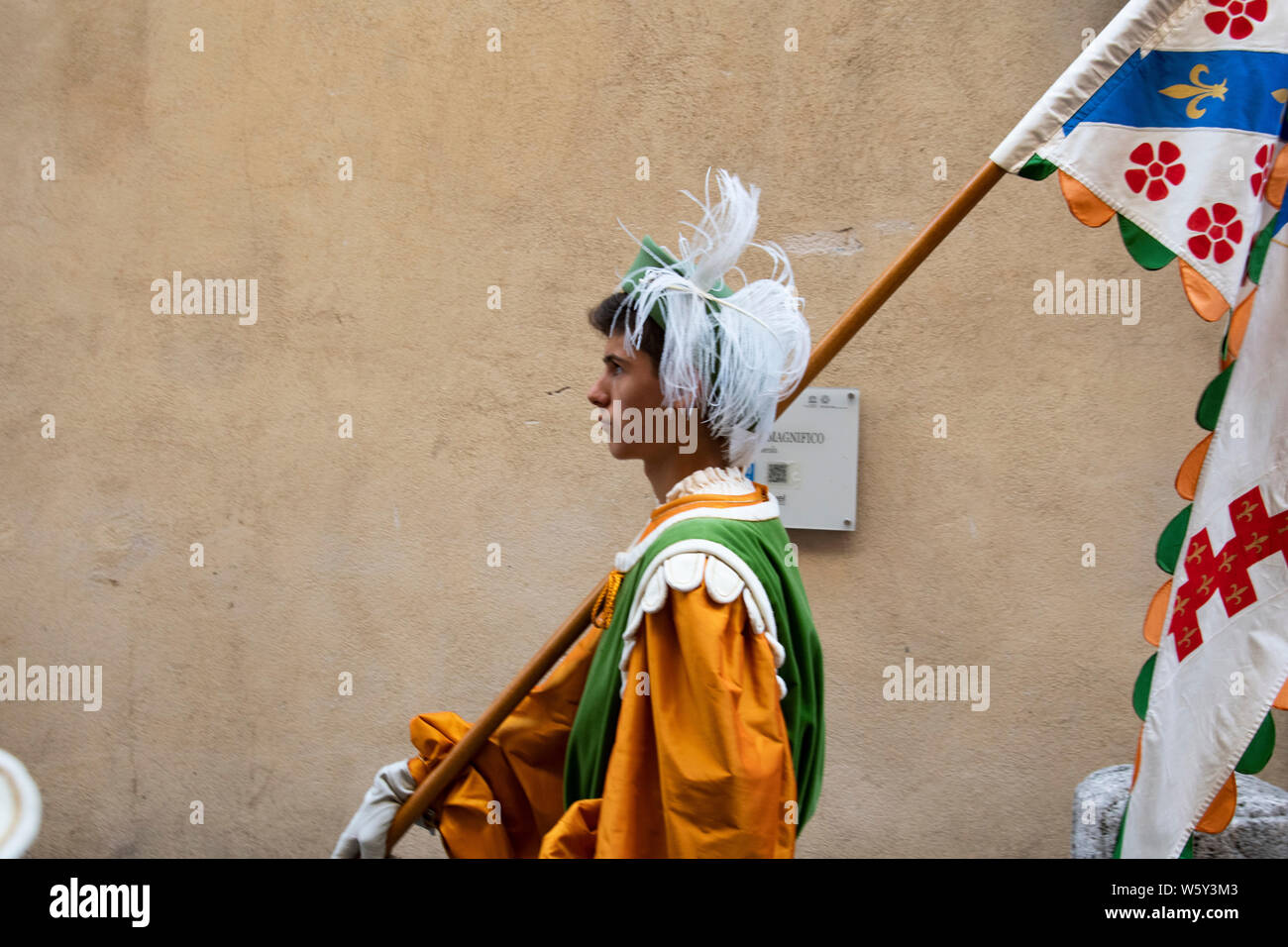 Young man in medieval costume carries a flag during the Palio parade in Siena, Italy Stock Photo