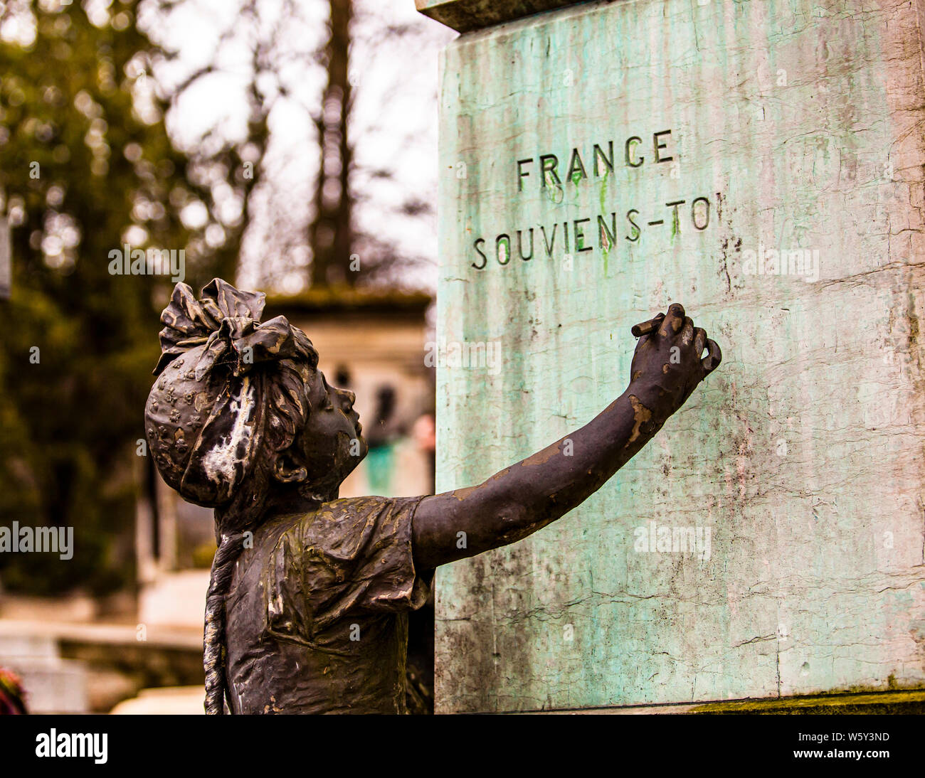 Bronze figure of a child at the base of a memorial inscribed "France, souviens-toi" ("France, remember") at the Père-Lachaise Cemetery in Paris. Taken on 18 February 2012. Stock Photo