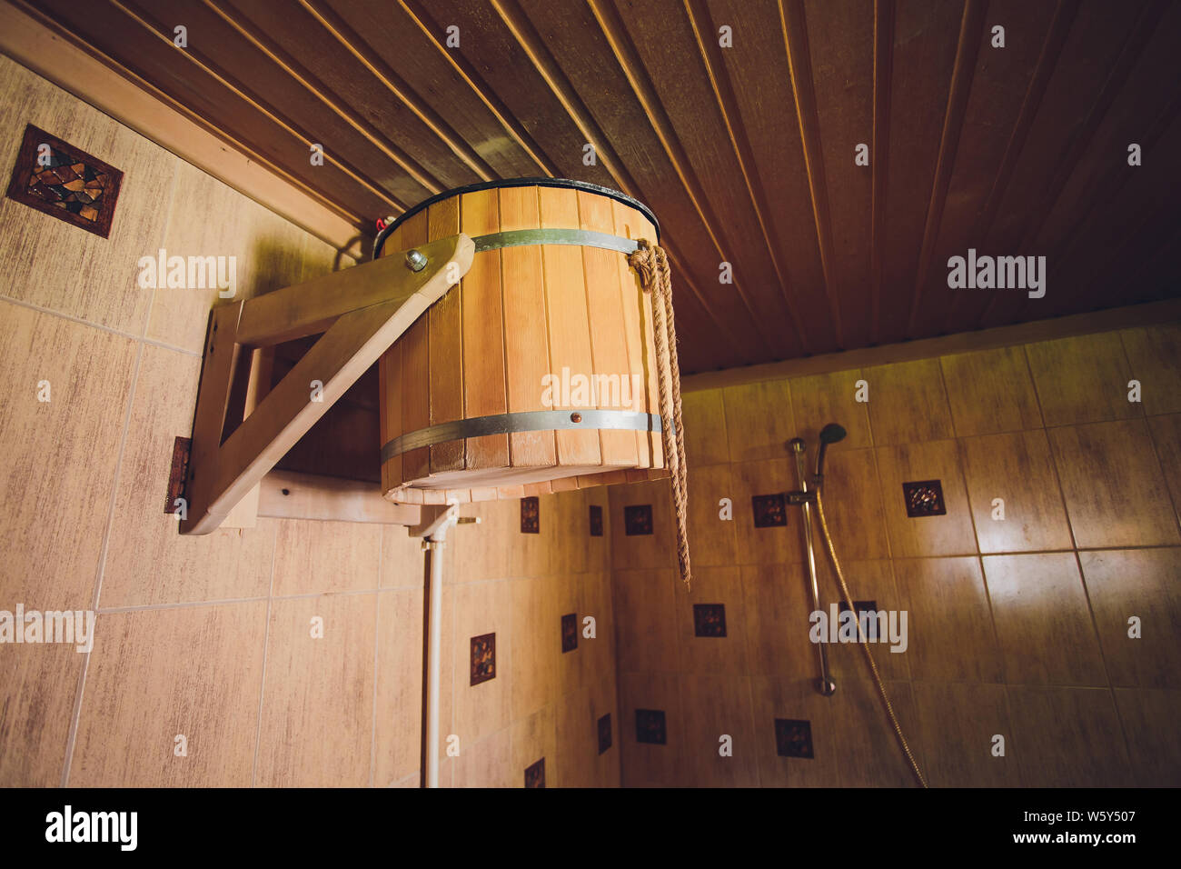 Part of the interior of the Russian bath and bath accessories. Bath accessories on the background of the log walls of the Russian bath. Stock Photo