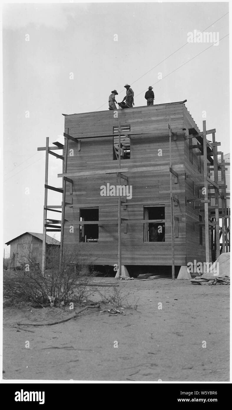 [Three Papago men working on top of structure for new pump house on the