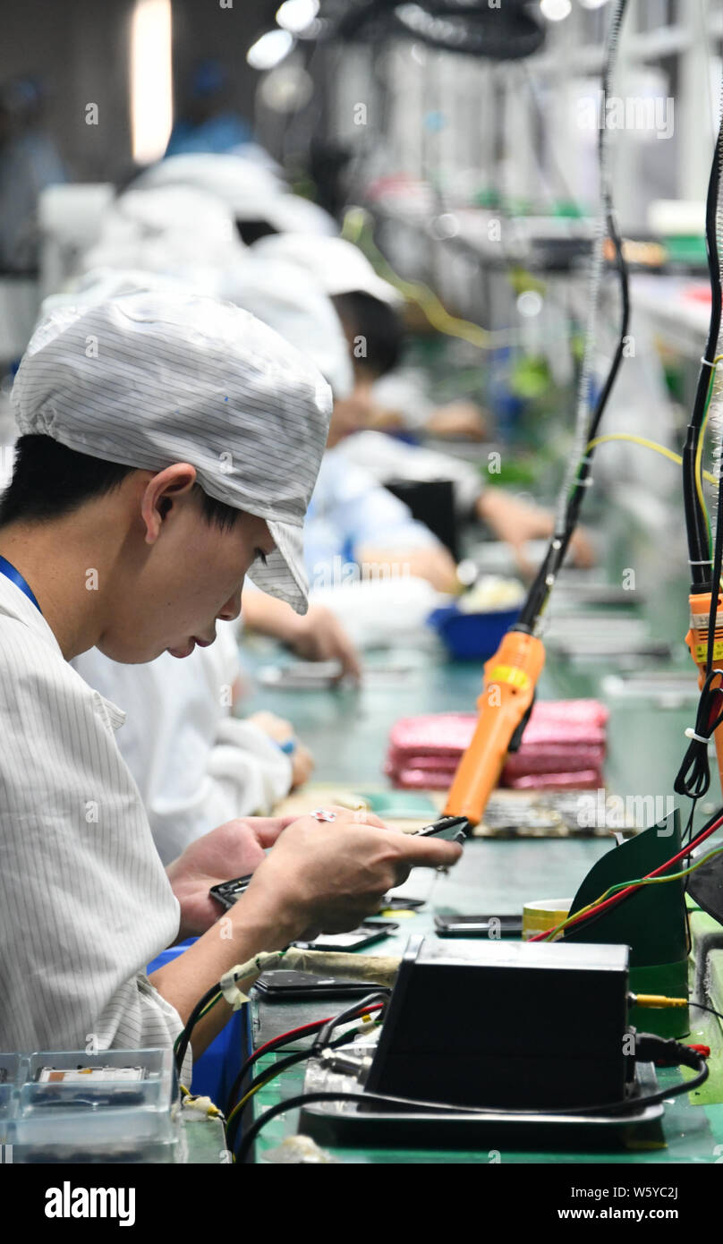 Chinese workers manufacture intelligent products on the assembly line ...