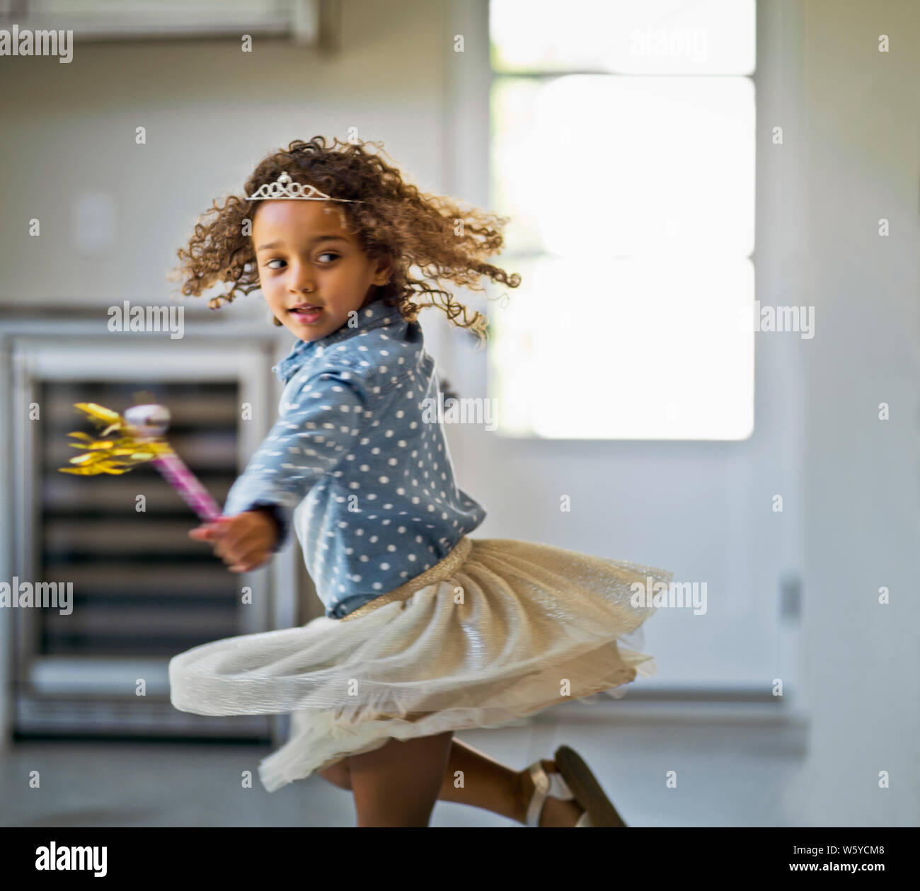 Happy young girl playing with a party blower Stock Photo - Alamy