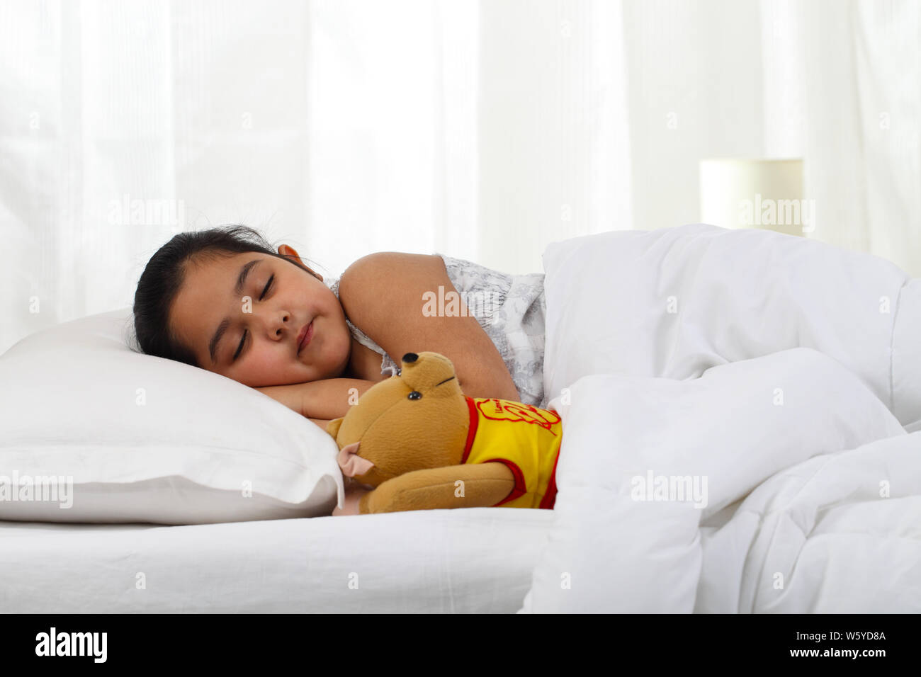 Girl with teddy bear sleeping in bed Stock Photo - Alamy