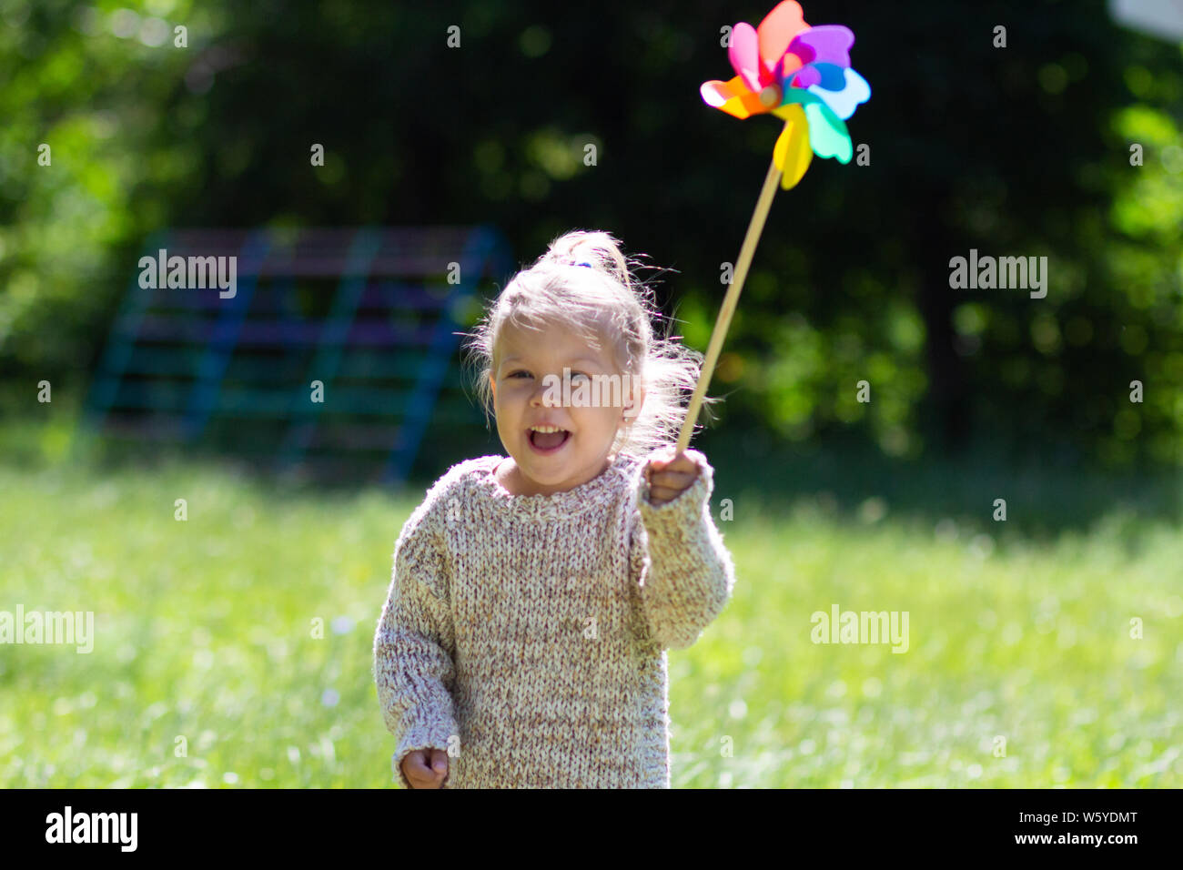 Child with Pinwheel in summer park looking at camera Stock Photo - Alamy