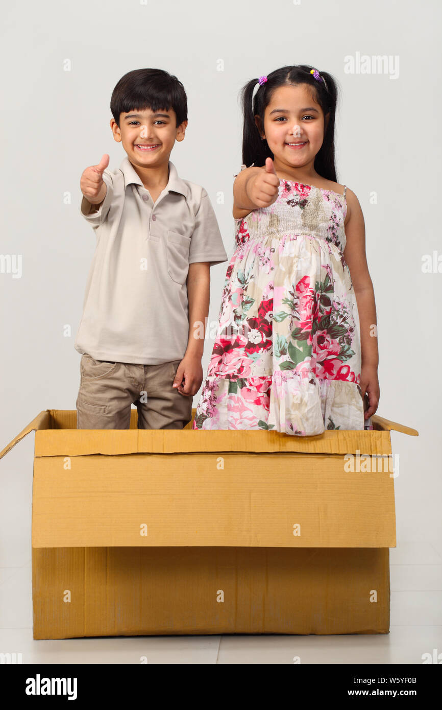 Two children showing thumbs up sign and smiling Stock Photo - Alamy