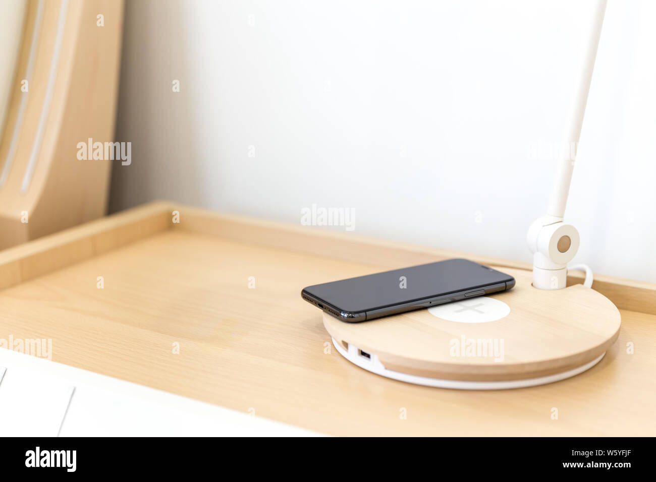 Wireless smartphone charging on lamp near bed Stock Photo Alamy
