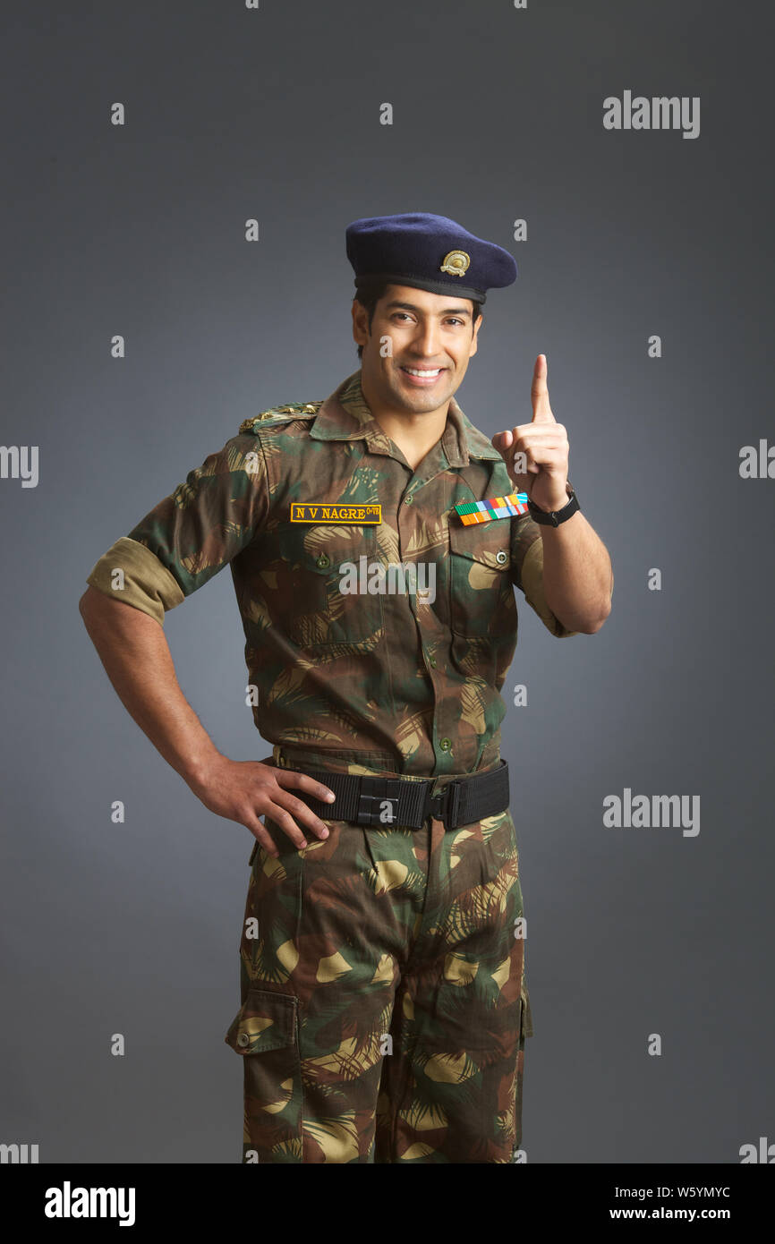 Army soldier pointing upward smiling Stock Photo Alamy