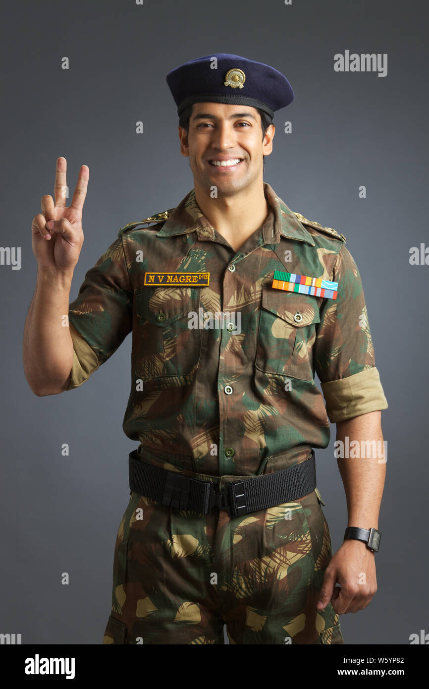 PORTRAIT OF INDIAN SOLDIER DRESSED IN UNIFORM FLASHING A VICTORY SIGN Stock  Photo - Alamy