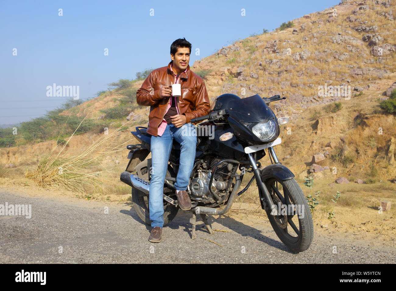 Man having tea on a motorcycle Stock Photo - Alamy