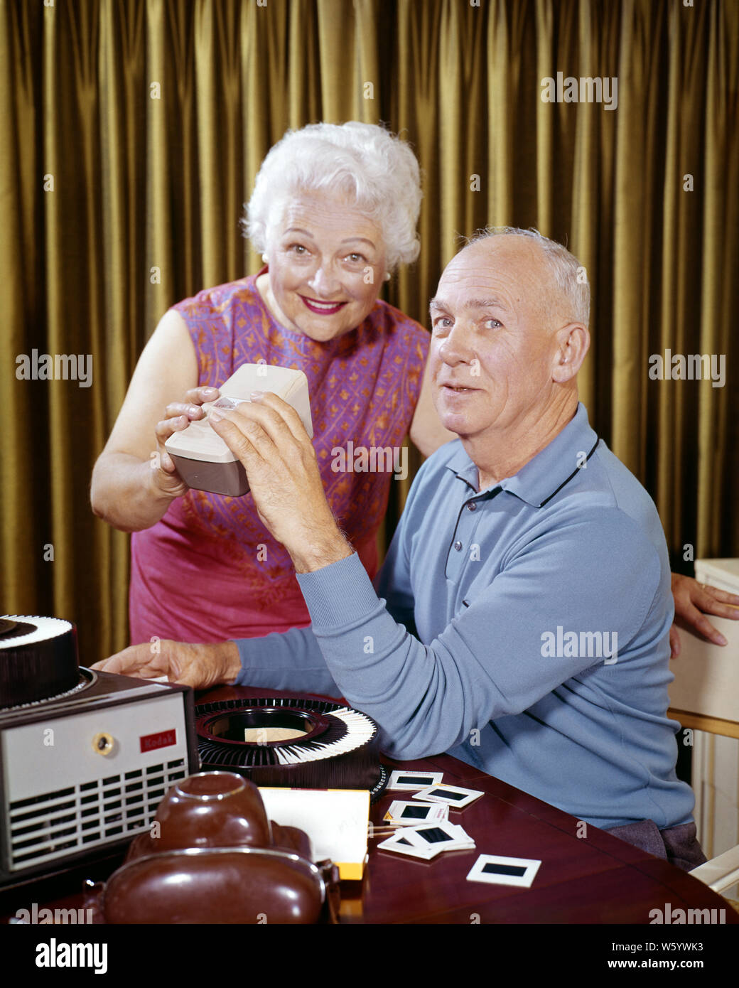 1960s SENIOR COUPLE MAN WOMAN HUSBAND WIFE AT HOME VIEWING EDITING FAMILY VACATION 35MM PHOTO SLIDES BESIDE CAMERA AND PROJECTOR - ks5129 HAR001 HARS NOSTALGIA OLD FASHION 1 COMMUNICATION TEAMWORK VACATION RELAXING PHOTOGRAPHS FAMILIES JOY LIFESTYLE SATISFACTION CELEBRATION ELDER FEMALES MARRIED SPOUSE HUSBANDS HEALTHINESS HOME LIFE COPY SPACE FRIENDSHIP HALF-LENGTH LADIES PERSONS INSPIRATION CAMERAS CARING MALES CONFIDENCE SENIOR MAN SENIOR ADULT PARTNER EYE CONTACT SENIOR WOMAN GOALS SUCCESS TIME OFF SKILL ACTIVITY AMUSEMENT DREAMS PROJECTOR HAPPINESS OLDSTERS OLDSTER DISCOVERY HOBBY LEISURE Stock Photo