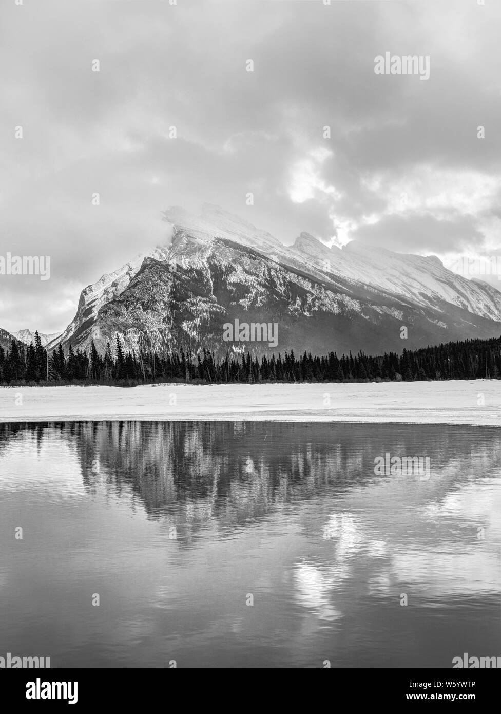 Black and white rendering of Vermilion Lakes during Winter in the Canadian Rockies of Banff National Park showing Mt Rundle and its reflections. Stock Photo