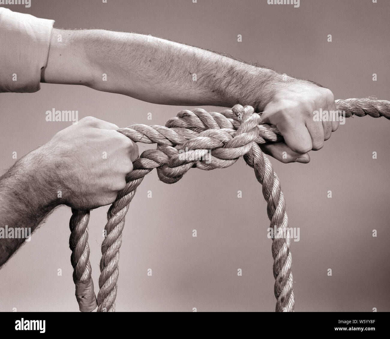 1960s MALE HANDS TYING SQUARE KNOT IN TWO ROPE LINES - s13713