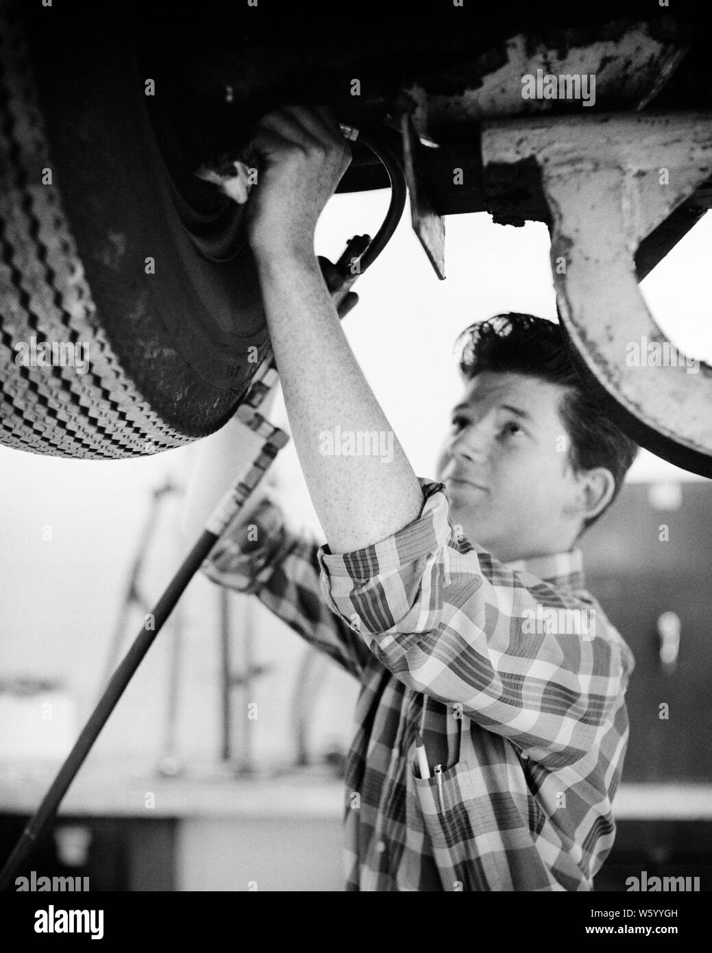 1950s 1960s Teen Boy Working On Car In Automotive Mechanics High