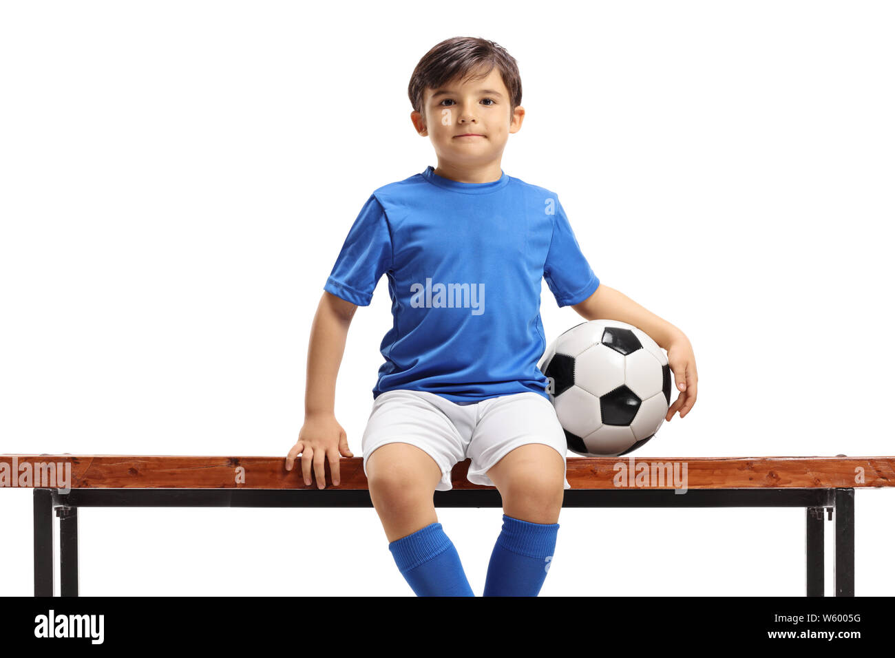 Boy with football sitting on a bench isolated on white background Stock Photo