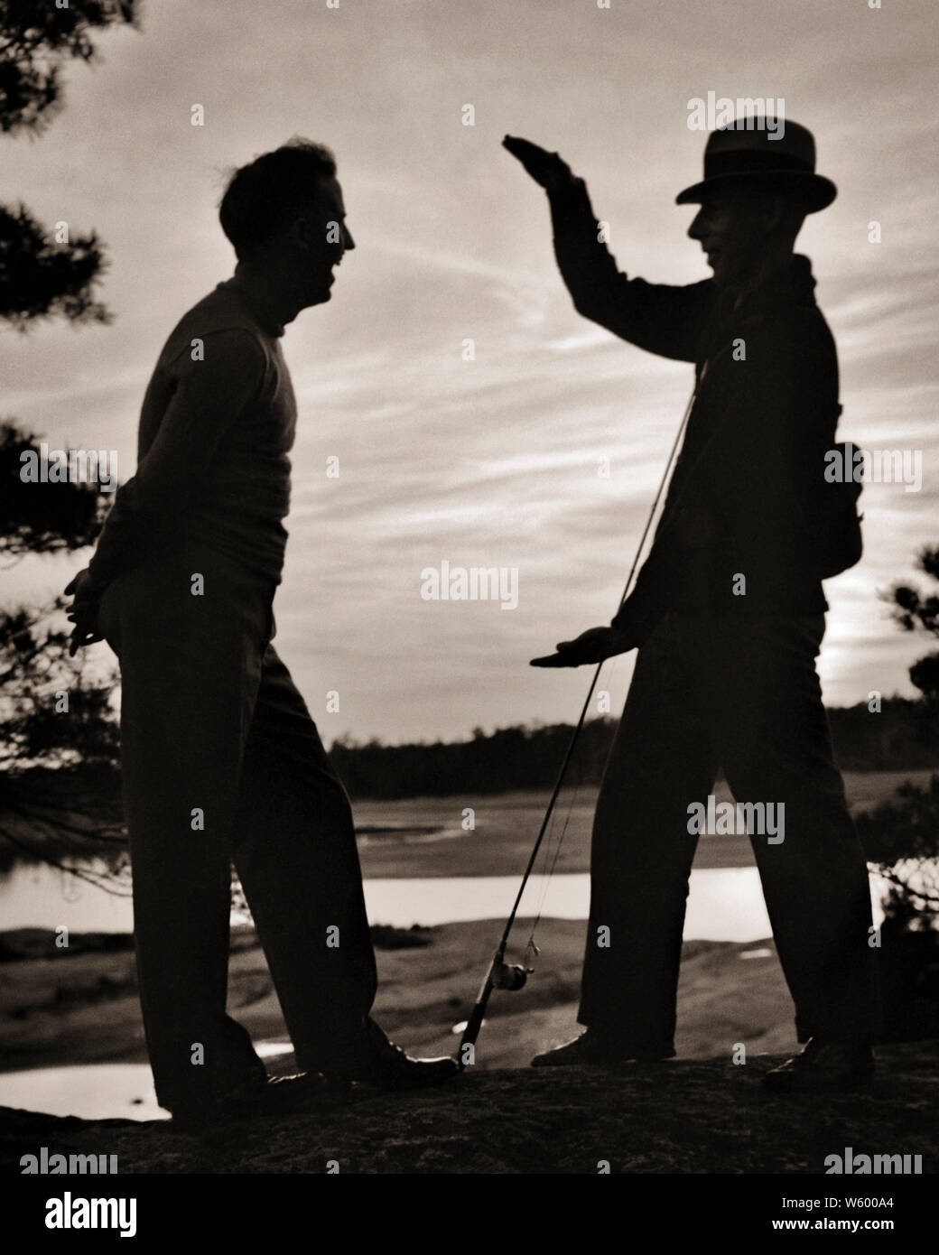 1950s ANONYMOUS SILHOUETTE OF TWO MEN ONE WEARING HAT HOLDING FISHING ROD  TELLING THE STORY OF THE BIG ONE THAT GOT AWAY - s2663 HAR001 HARS LEISURE  SILHOUETTED RECREATION COMICAL TELLING CONNECTION