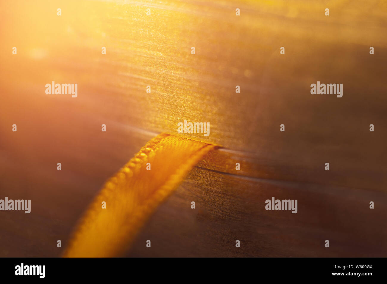 Golden book with orange ribbon bookmark Stock Photo - Alamy