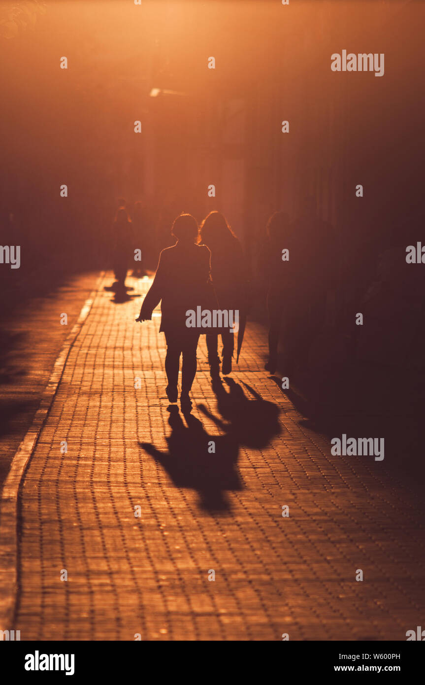 People silhouettes walking through the city at sunset Stock Photo - Alamy