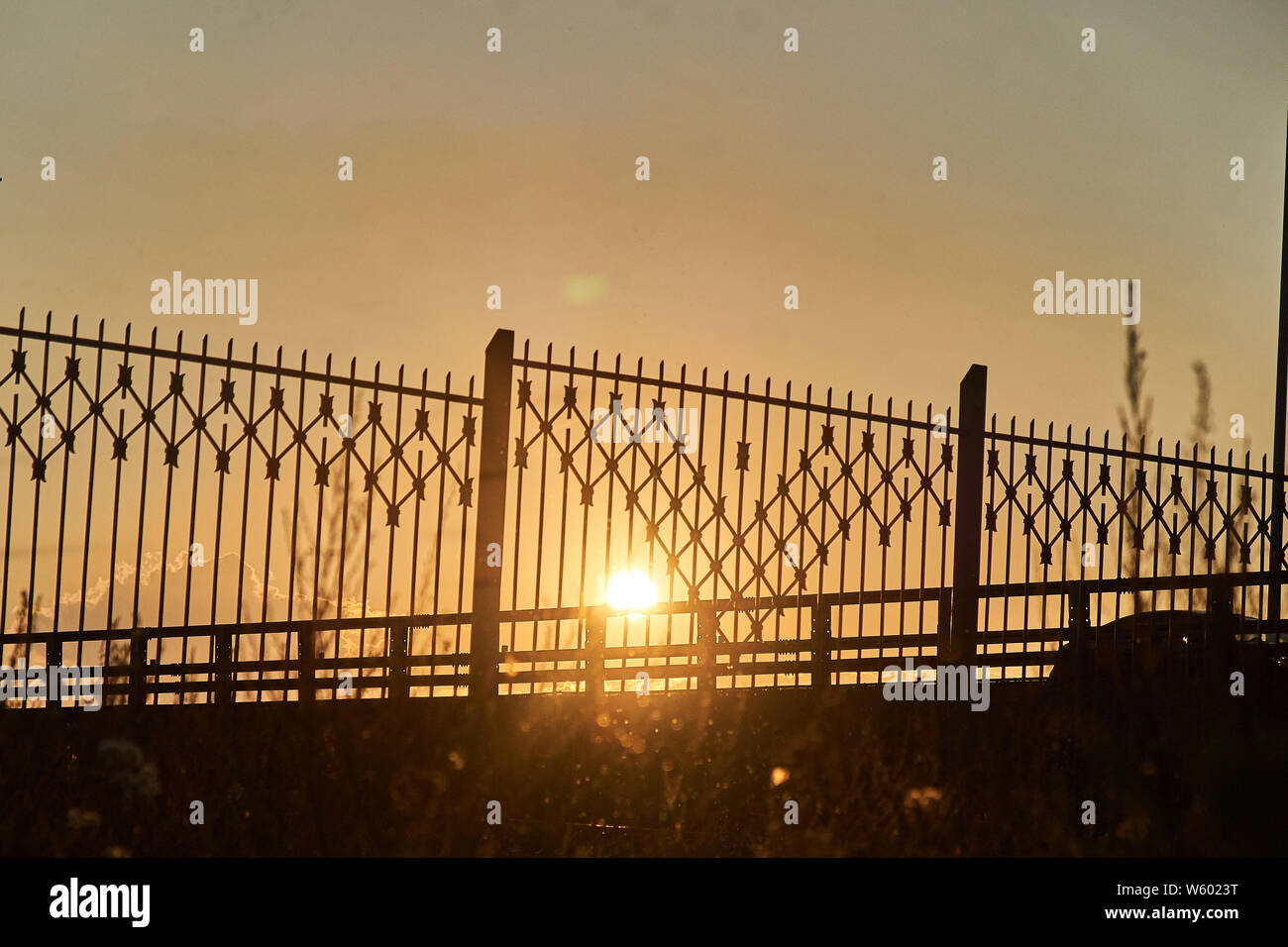 fence against the setting sun. backlit photo Stock Photo