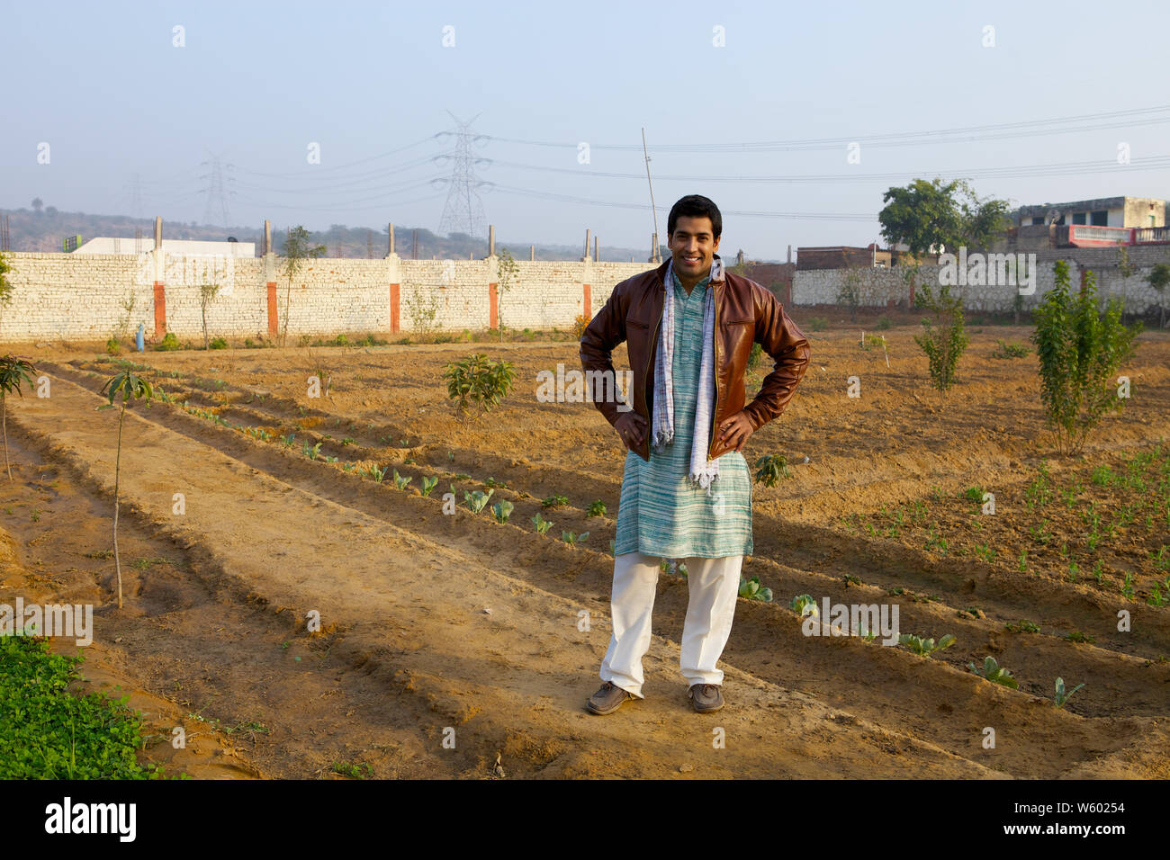 Farmer standing in a field with arms akimbo Stock Photo - Alamy