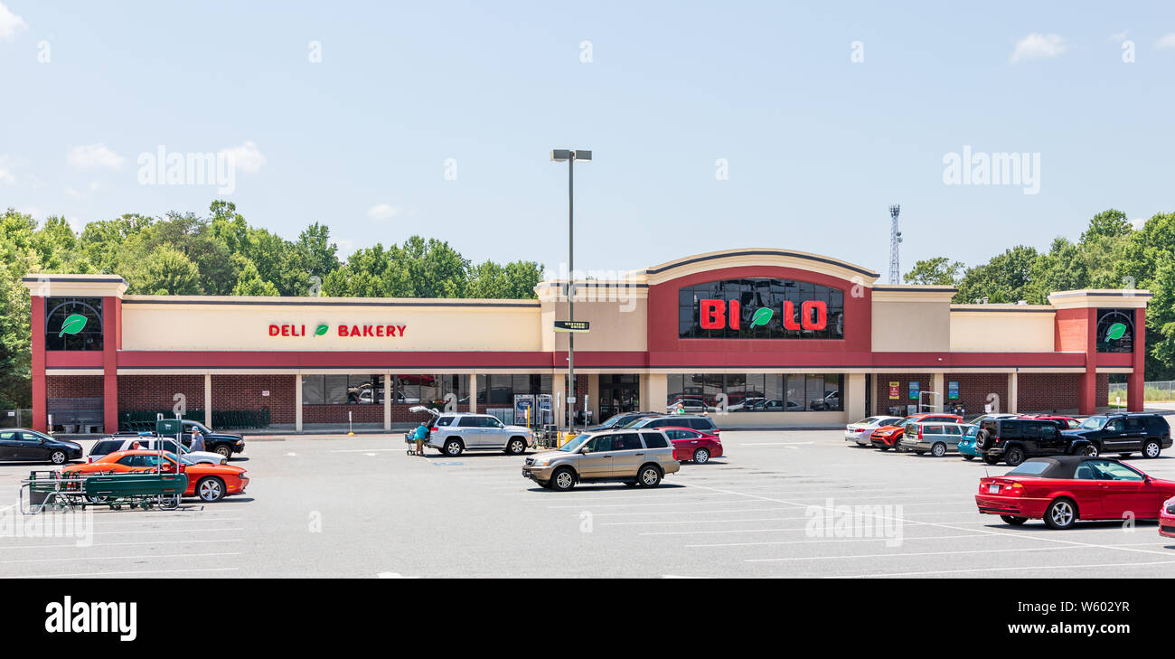SPINDALE, NC, USA-27 jULY 19:  A Bi-Lo supermarket in Spindale, showing parking lot, store front, and people loading food into their cars. Stock Photo