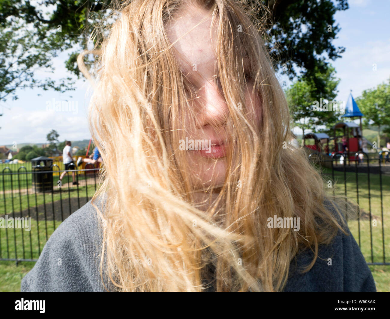 Blonde Teenage girl messing around with her messy hair Stock Photo