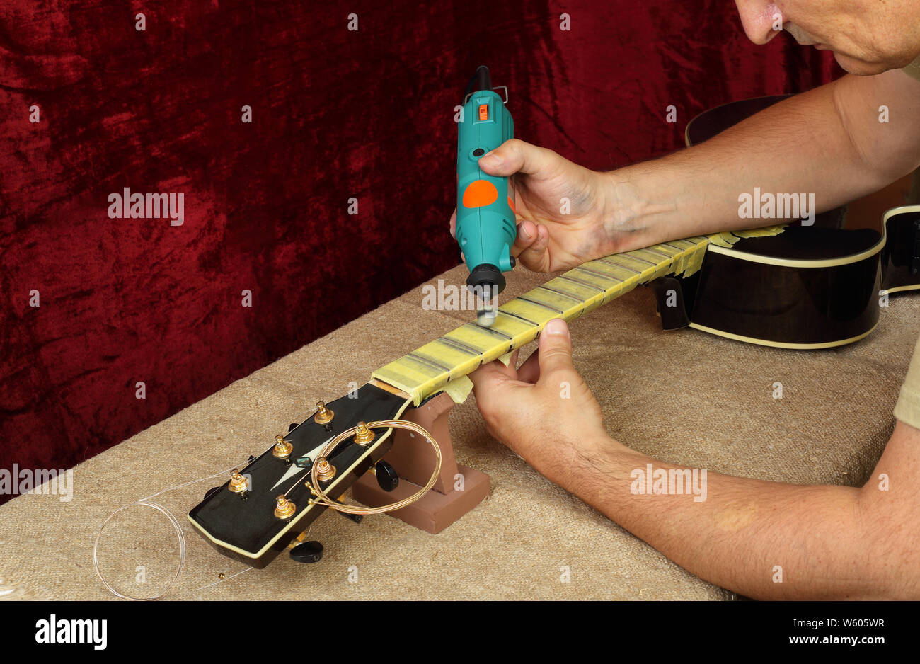 Musical instrument guitar repair and service Worker polishing guitar