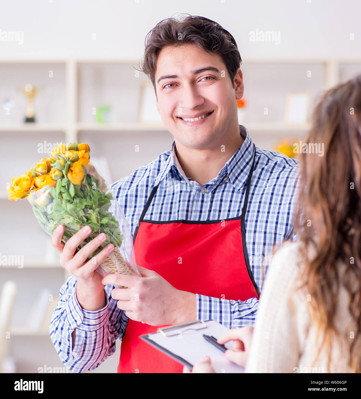 The flower shop assistant selling flowers to female customer Stock Photo Alamy
