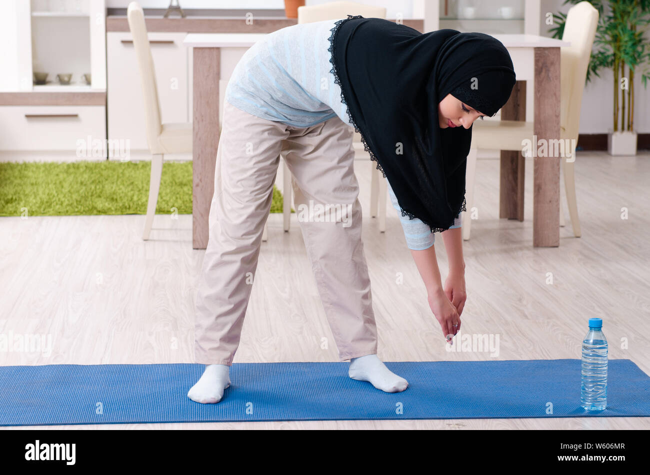 The young woman in hijab doing exercises at home Stock Photo - Alamy