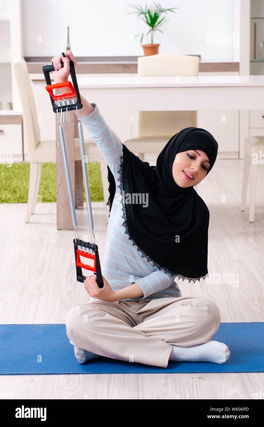 The young woman in hijab doing exercises at home Stock Photo - Alamy