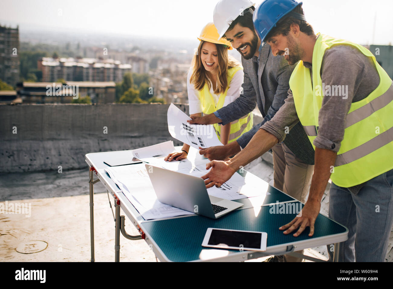 Architects team and engineers looking paper plans at construction site. Stock Photo
