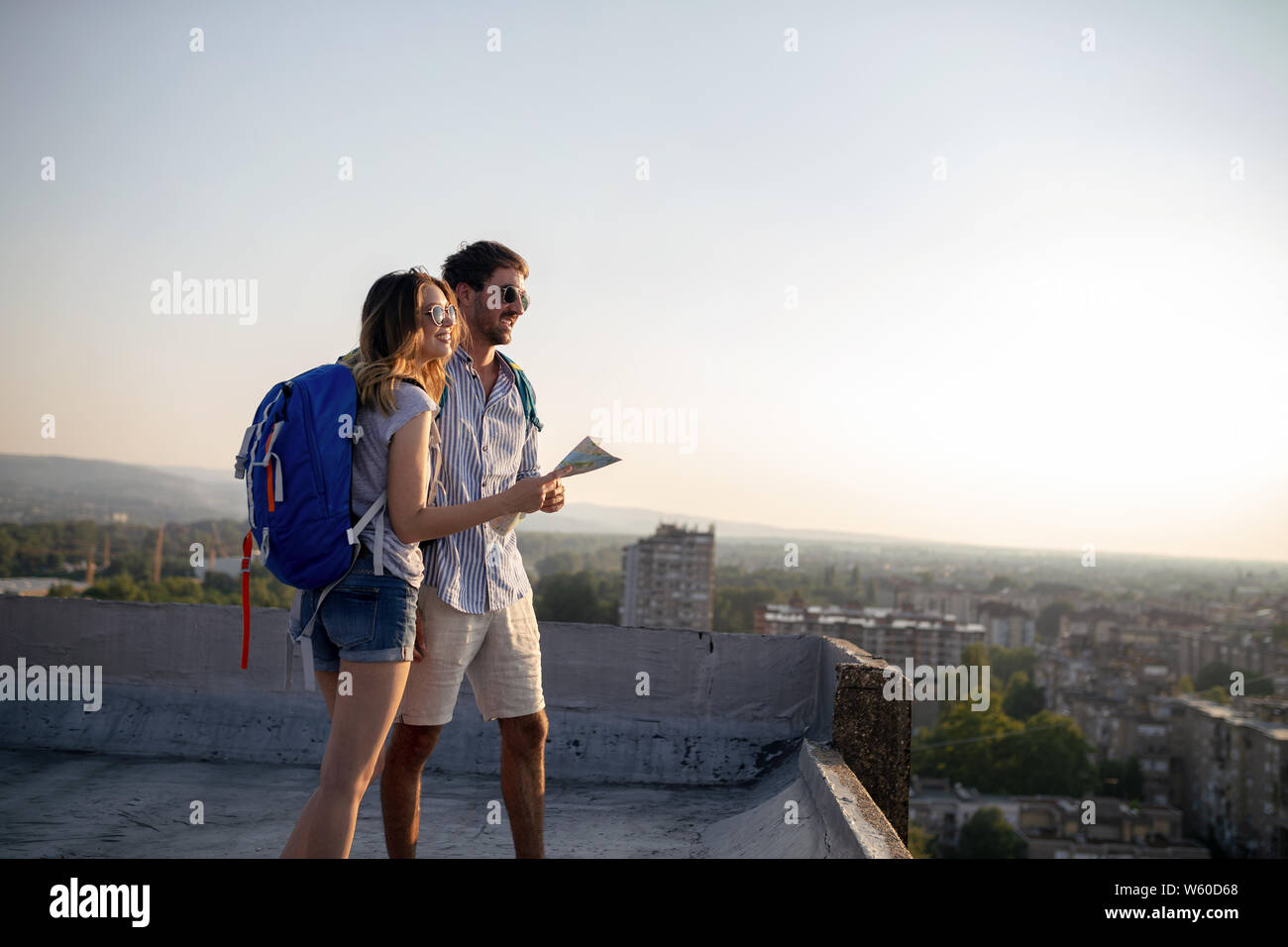 Happy young couple of travellers holding map in hands Stock Photo