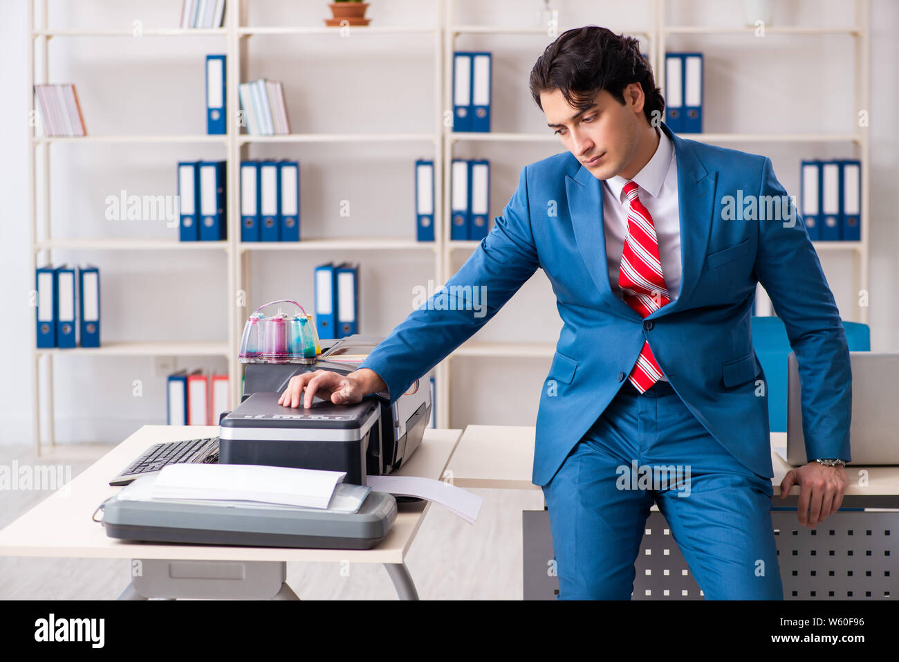 Working Copy Cop The young employee making copies at copying machine Stock Photo - Alamy