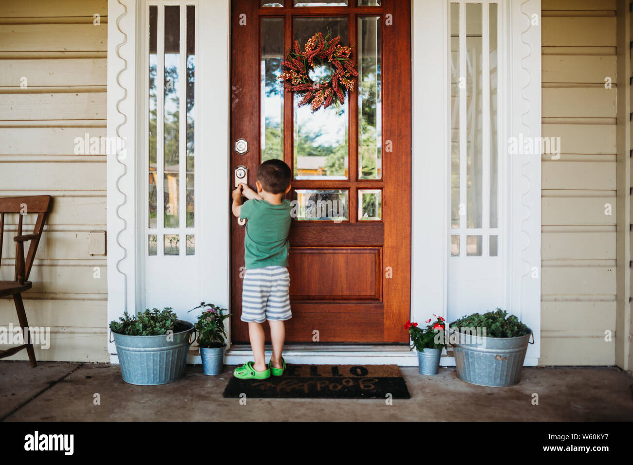 Young boy opening front door in summer Stock Photo Alamy