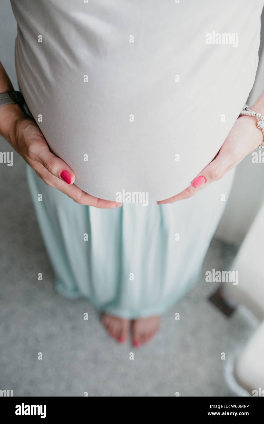Belly and hands of pregnant woman Stock Photo