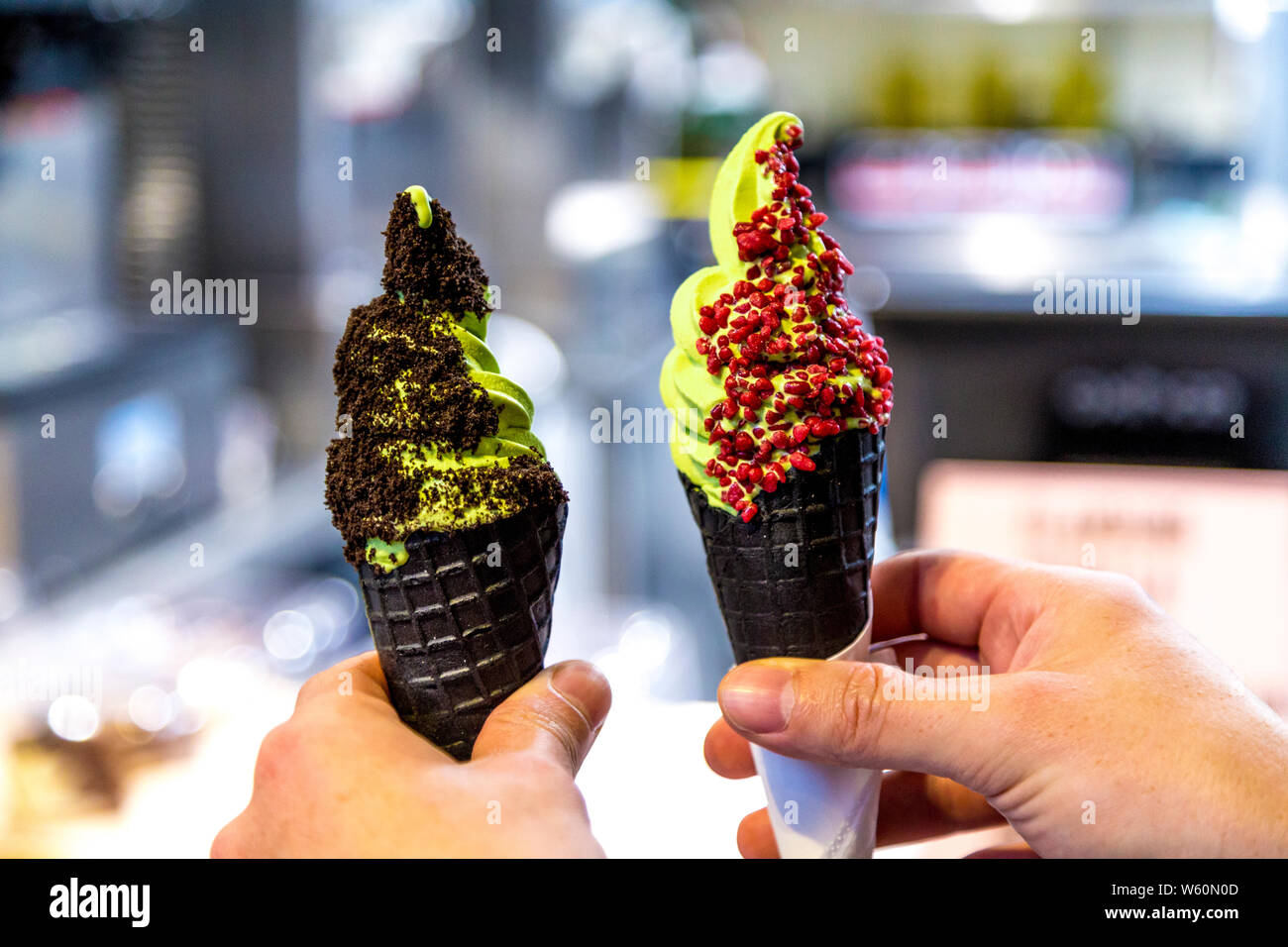 Matcha soft serve ice cream in black cone with toppings at Market Hall Victoria, London, UK Stock Photo