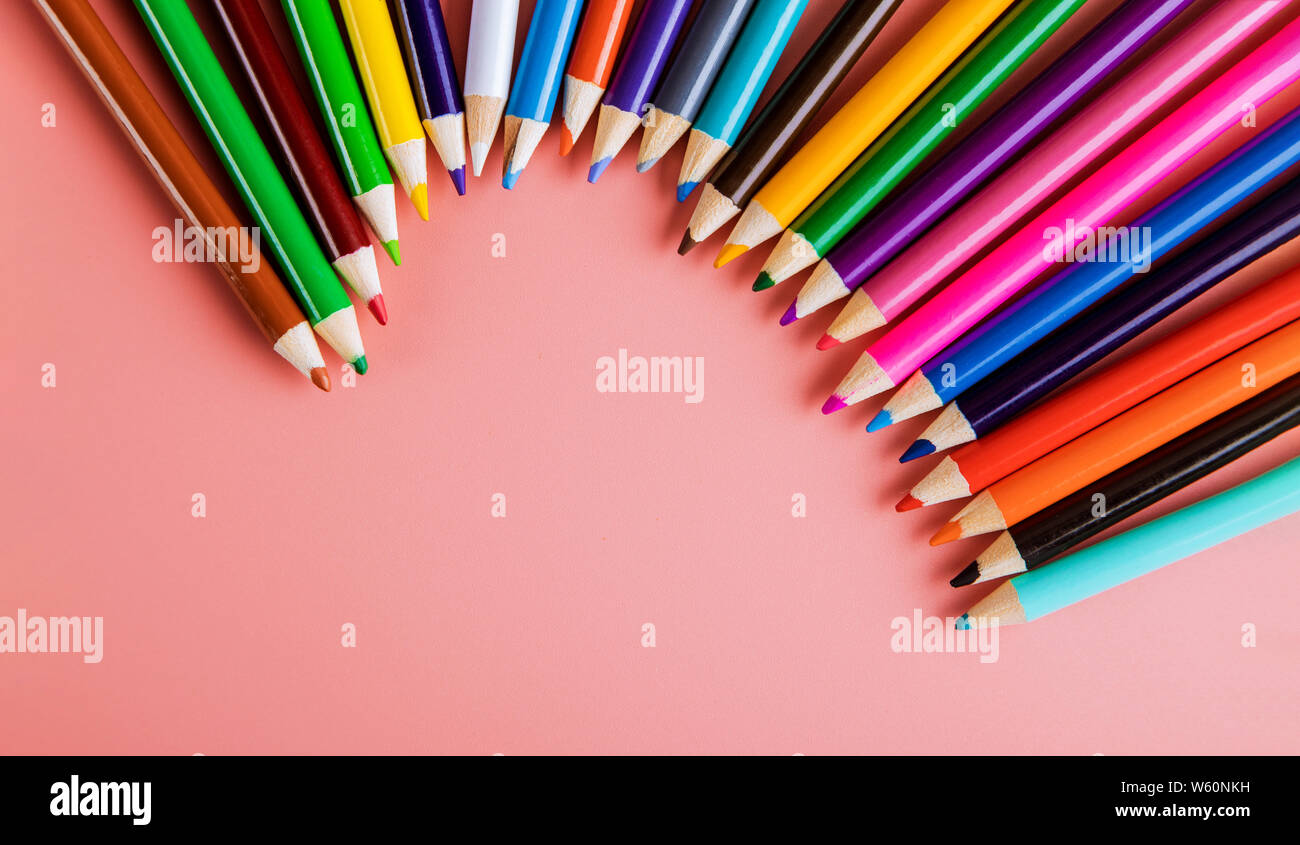 Colored pencils for art classes and school on pink background Stock