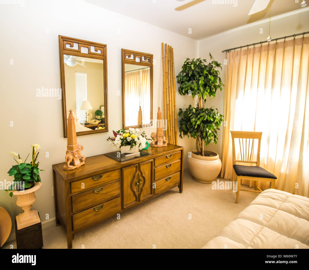 Bedroom With Dresser Mirrors And Bamboo Decorations Stock Photo