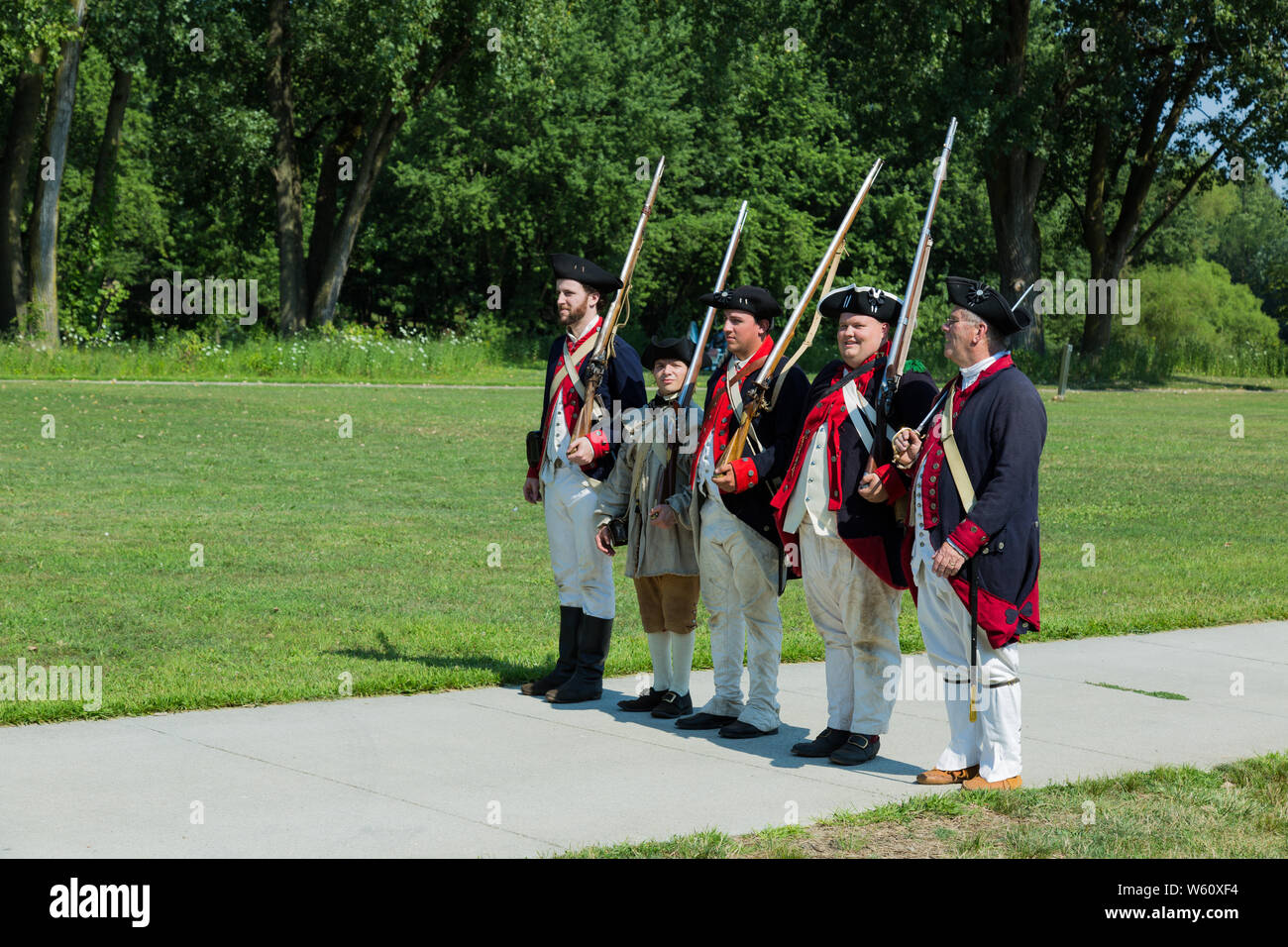 Reenactors in Continental Army uniforms line up in a military formation during an event at Historic Fort Wayne in Fort Wayne, Indiana, USA. Stock Photo
