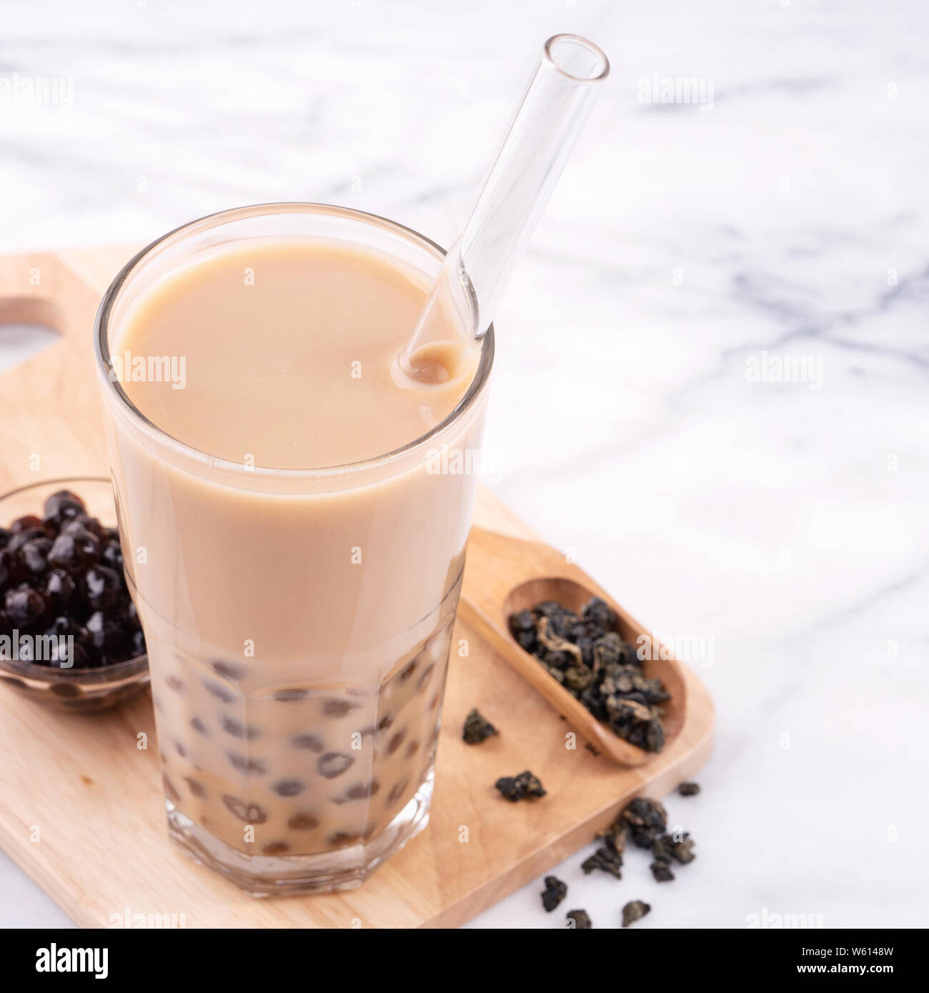 https://c8.alamy.com/comp/W6148W/tapioca-pearl-ball-bubble-milk-tea-popular-taiwan-drink-in-drinking-glass-with-straw-on-marble-white-table-and-wooden-tray-close-up-copy-space-W6148W.jpg