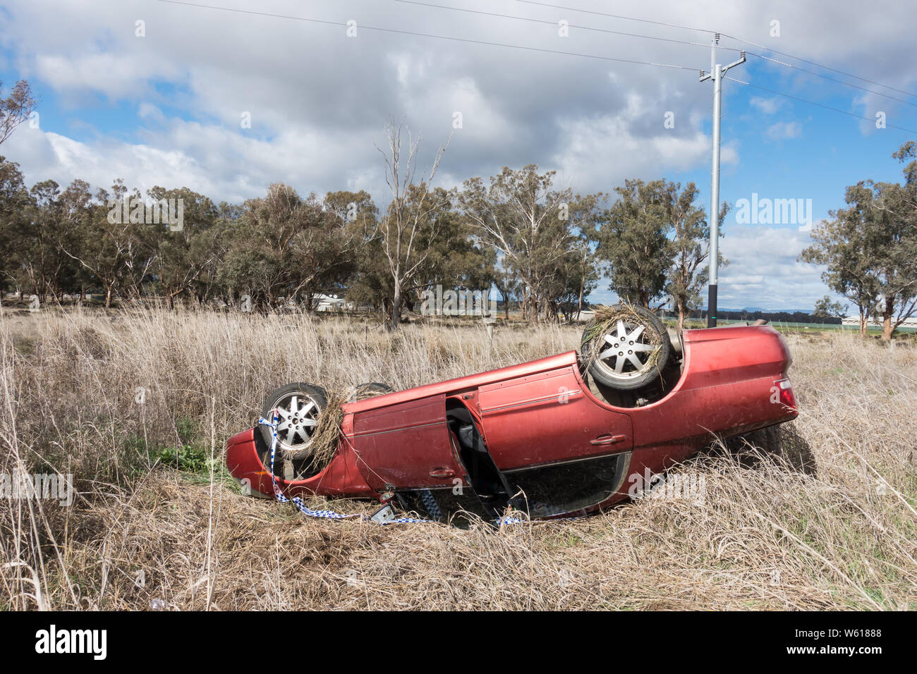 Red car in roll over accident on country road, Australia. Stock Photo